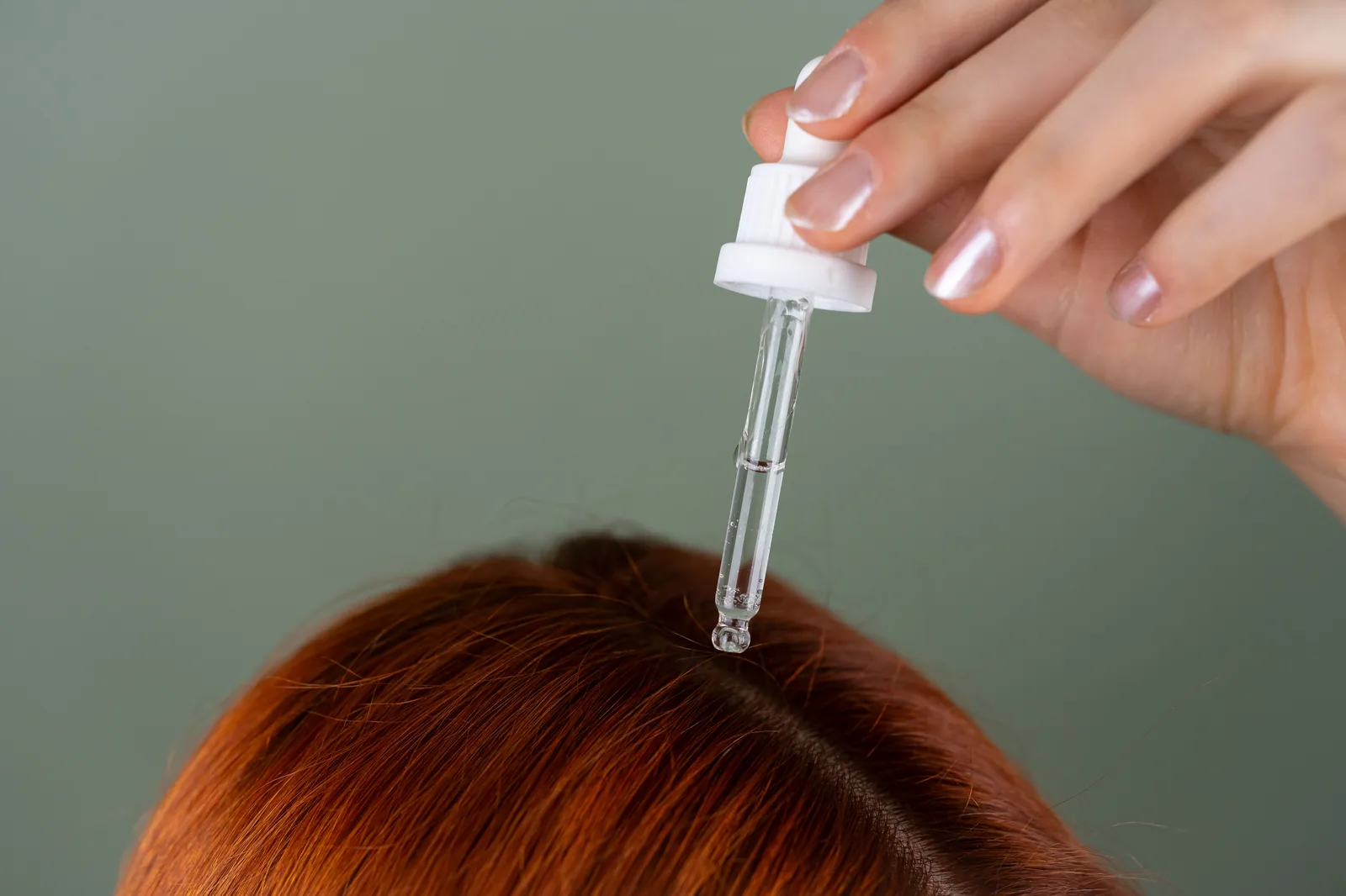 Aplicando minoxidil no couro cabeludo com conta-gotas