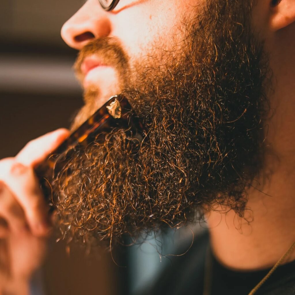 Homem aplicando óleo na barba com pente
