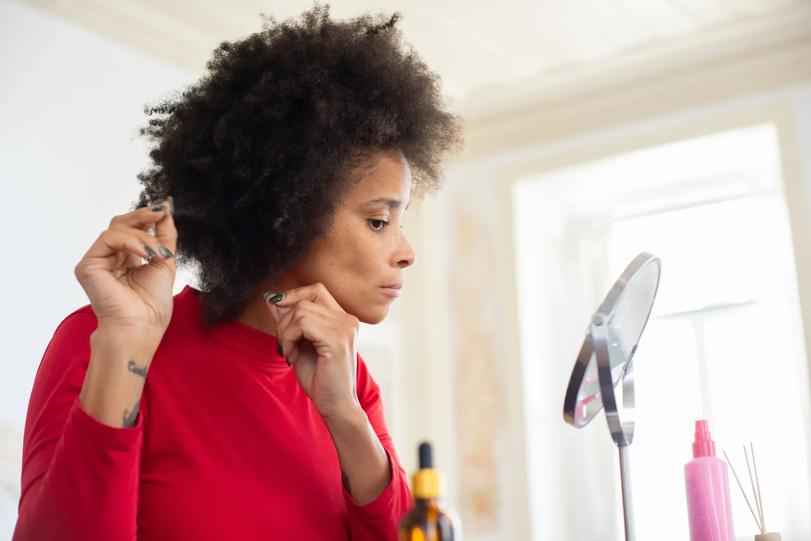 Mulher examinando o cabelo e a linha do couro cabeludo