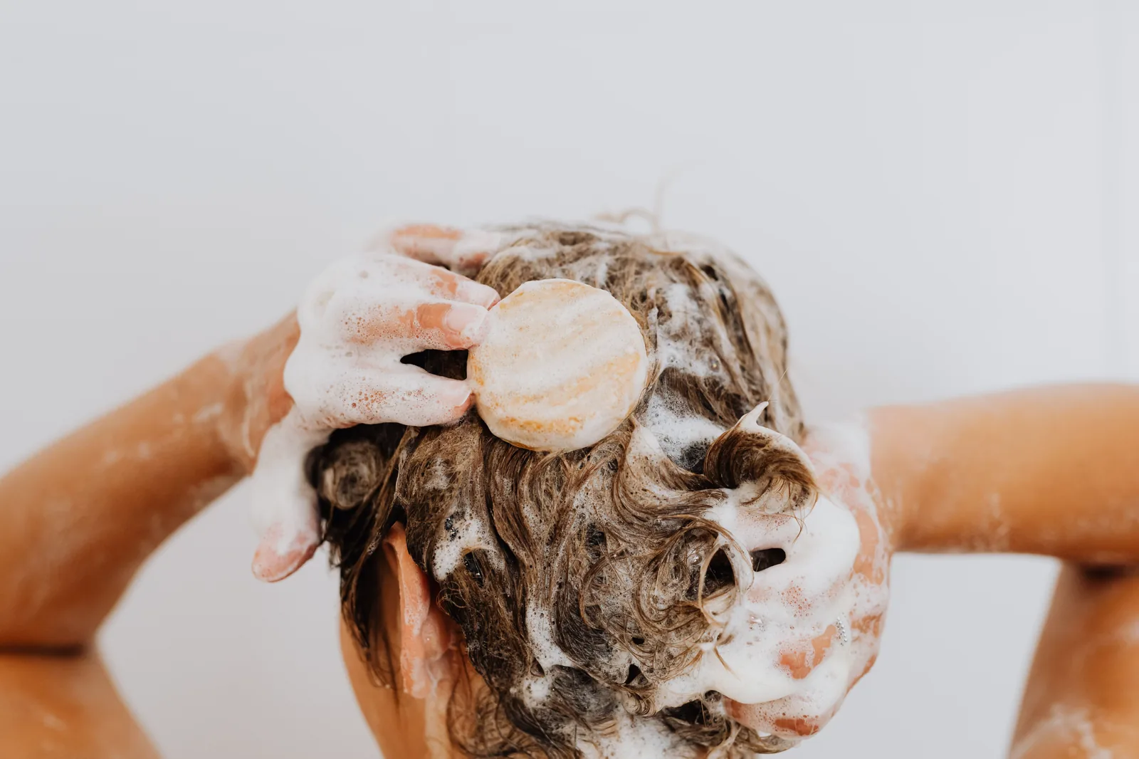 Lavando o cabelo com shampoo em barra no chuveiro